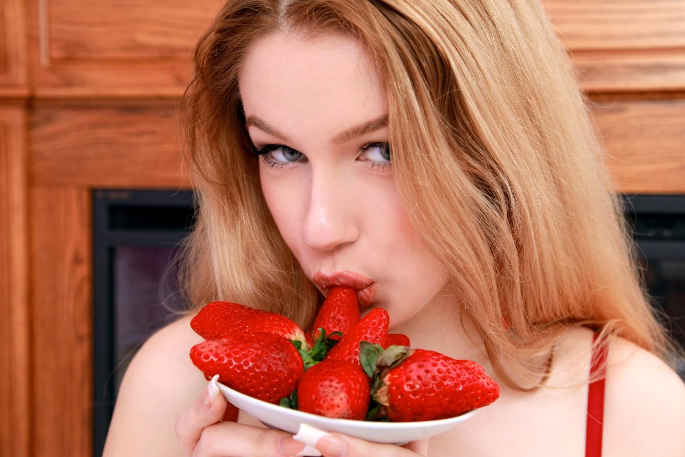 Naked blonde with shaved pussy Erica B is erotically eating the strawberrie...